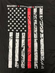 Close-up of the back of Black Fire Department Tshirt with vertical white American Flag with one red stripe.